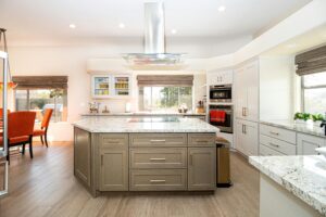 A newly renovated kitchen with white countertops and a large island, demonstrating the possibilities of applied kitchen renovation costs.